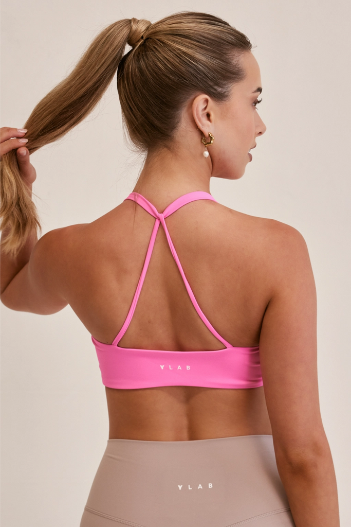 Model wearing YLAB Ultra Fusion Sports Bra in Candy